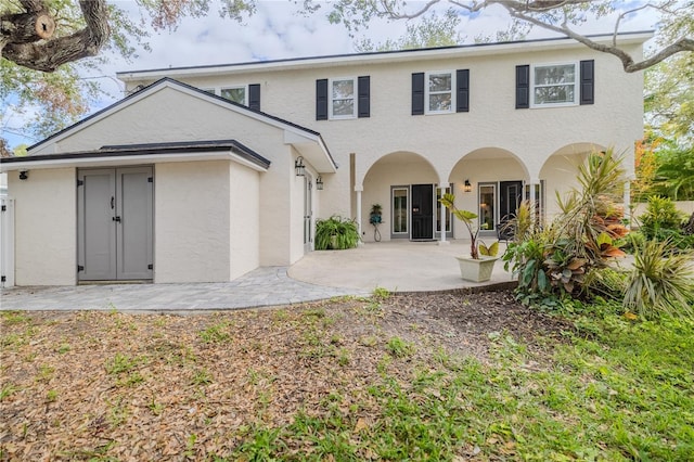 back of property with a patio area and stucco siding