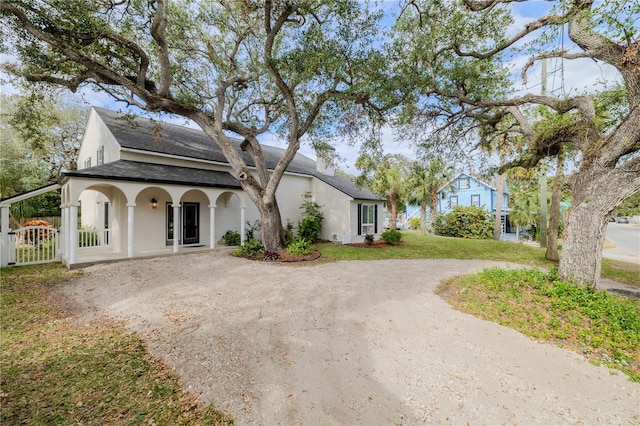 view of front of home featuring driveway, a front lawn, and stucco siding