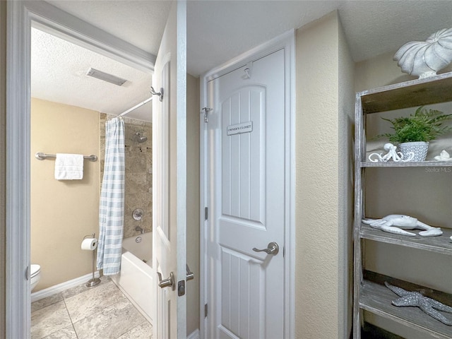 111 N Atlantic Ave Unit A219, New Smyrna Beach, FL 32169 - full bath featuring shower / bathtub combination with curtain, visible vents, toilet, baseboards, and a textured ceiling