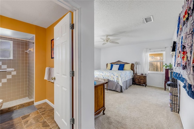 carpeted bedroom featuring a textured ceiling, a fireplace, visible vents, and baseboards