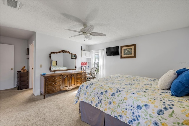 bedroom with light colored carpet, visible vents, ceiling fan, and a textured ceiling