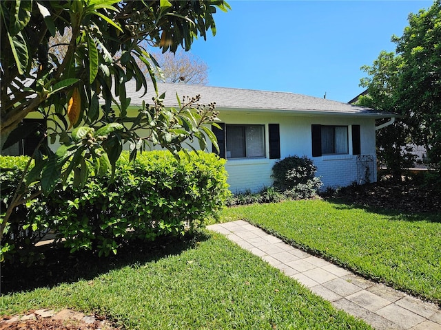 view of front facade with a front lawn and brick siding