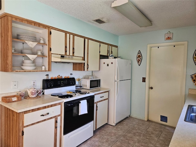 kitchen featuring light countertops, visible vents, a textured ceiling, white appliances, and under cabinet range hood