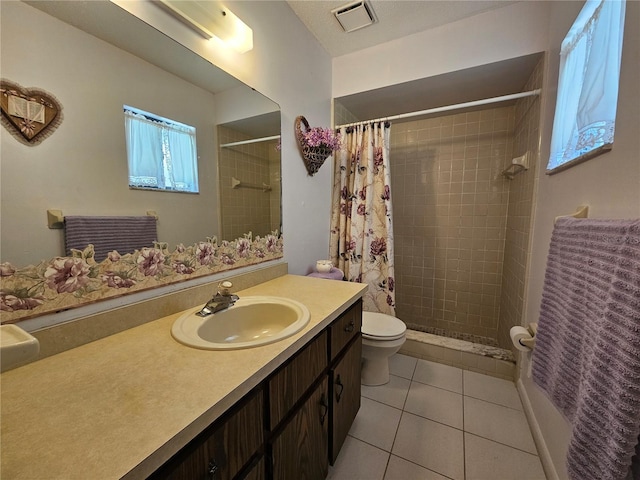 full bathroom featuring toilet, visible vents, tiled shower, and tile patterned floors