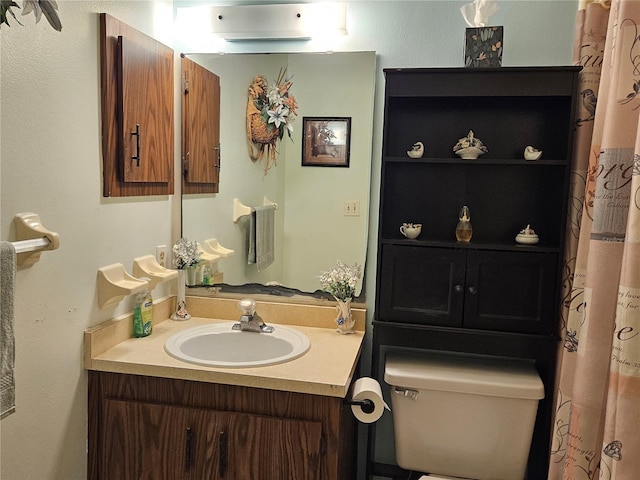 bathroom with an AC wall unit, vanity, and toilet