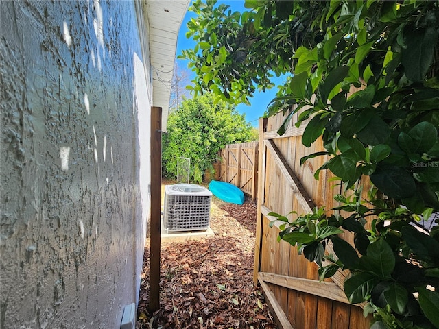 view of yard with fence and central air condition unit