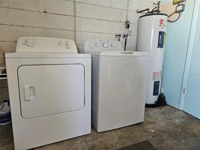 washroom featuring concrete block wall, laundry area, water heater, and independent washer and dryer