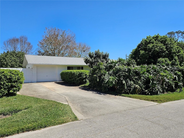 single story home featuring a garage, driveway, and fence