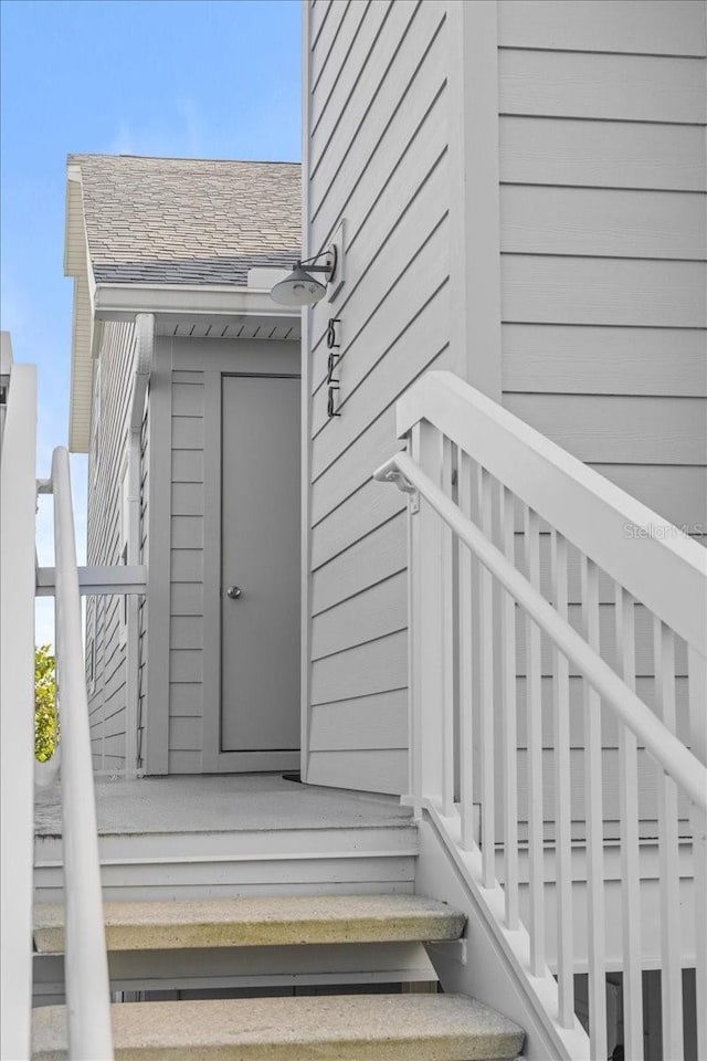 doorway to property with a shingled roof