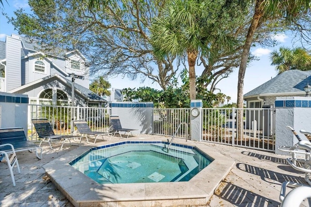 view of pool with a community hot tub and fence