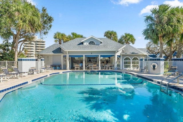 community pool with a patio and fence