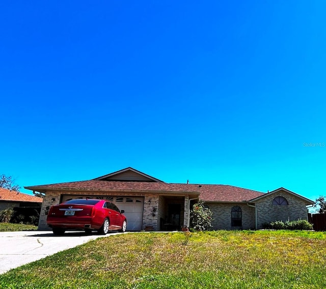 single story home with brick siding, a front lawn, concrete driveway, and a garage