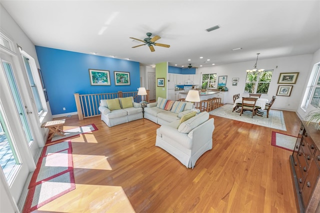 living room with recessed lighting, baseboards, visible vents, and light wood finished floors