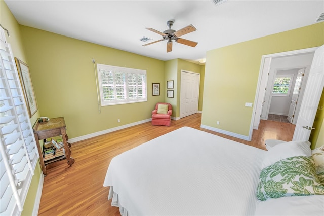 bedroom featuring a ceiling fan, light wood-type flooring, and baseboards