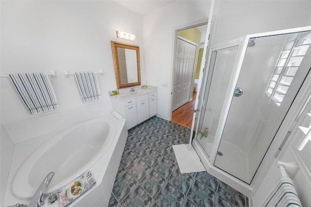 bathroom featuring a shower stall, a bath, and vanity