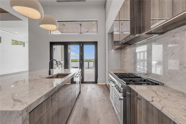 kitchen featuring appliances with stainless steel finishes, modern cabinets, a sink, and tasteful backsplash