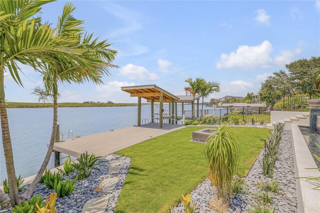 dock area featuring a lawn, a water view, and fence