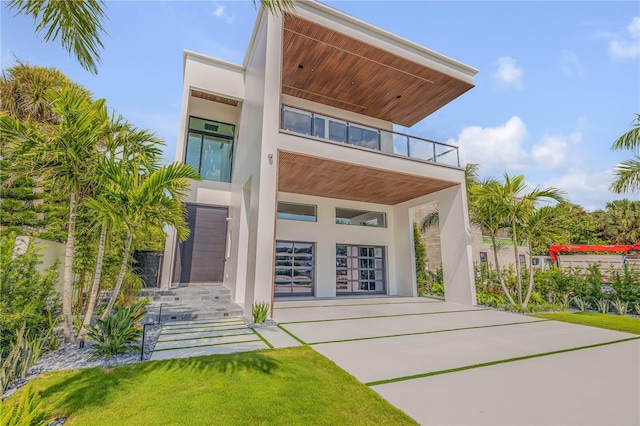 back of property featuring a balcony and stucco siding