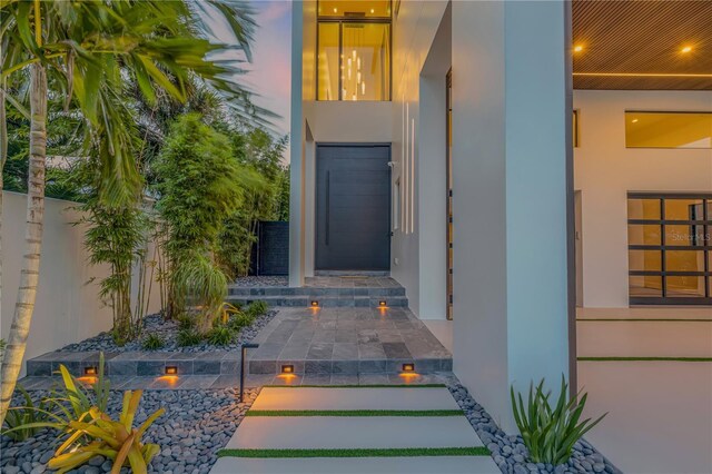 property entrance with fence and stucco siding