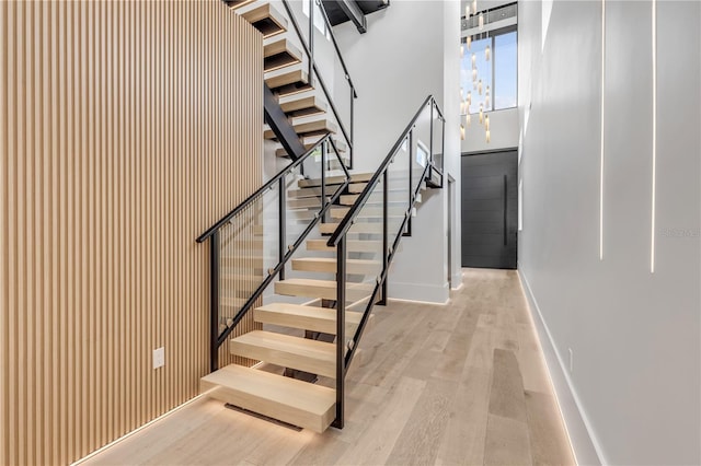 staircase featuring wood finished floors and baseboards