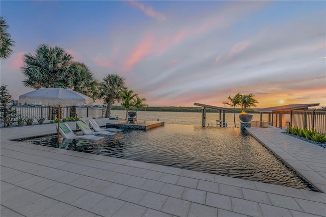 view of swimming pool with a dock and fence