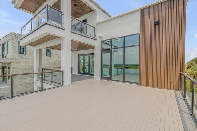 back of property with a balcony and stone siding