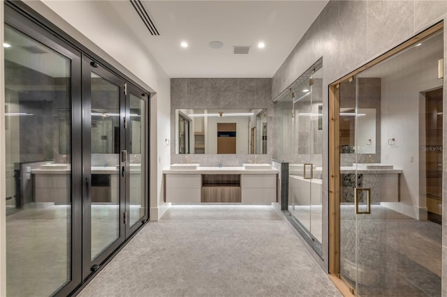 bathroom featuring vanity, a stall shower, and french doors