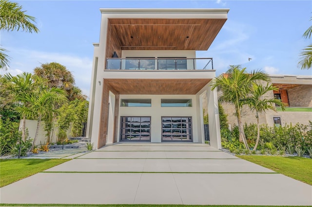 1194 N Peninsula, New Smyrna Beach, FL 32169 - contemporary house featuring a balcony, stucco siding, driveway, and a garage