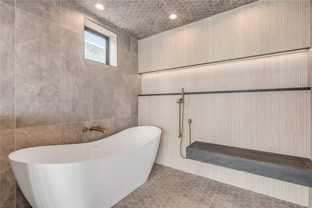 1194 N Peninsula, New Smyrna Beach, FL 32169 - full bathroom with a freestanding bath and tile walls