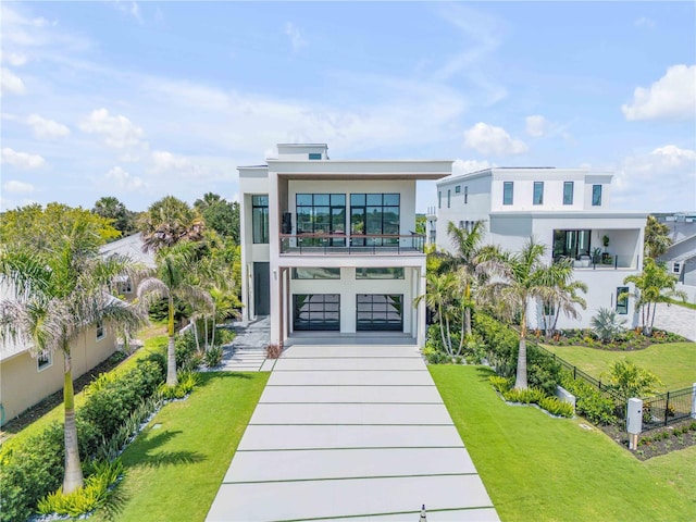 1194 N Peninsula, New Smyrna Beach, FL 32169 - view of front of property with concrete driveway, a balcony, stucco siding, and a garage