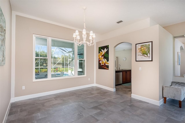 unfurnished dining area featuring visible vents, baseboards, a chandelier, arched walkways, and a sink