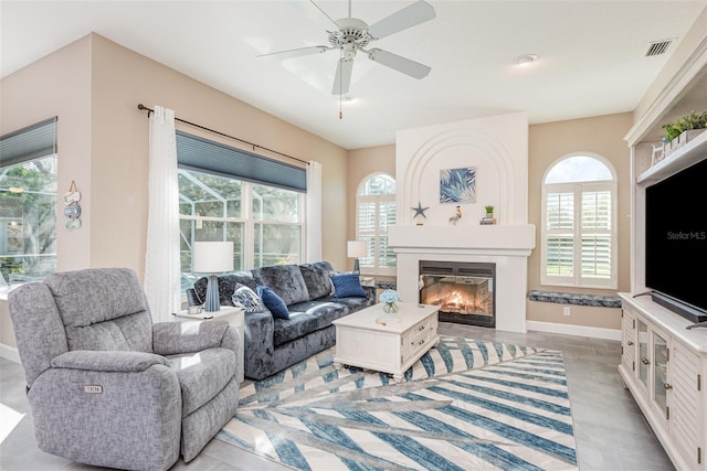 living area with visible vents, baseboards, a healthy amount of sunlight, and a fireplace