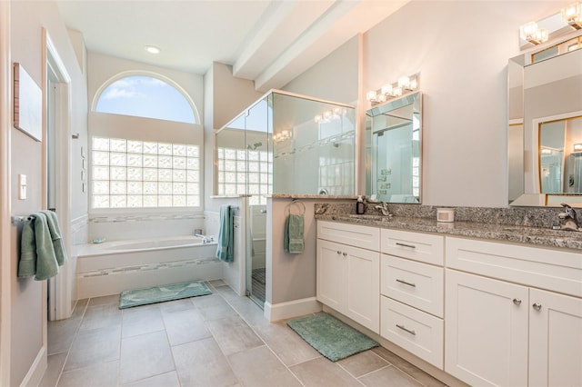 bathroom featuring double vanity, a garden tub, a healthy amount of sunlight, and a stall shower