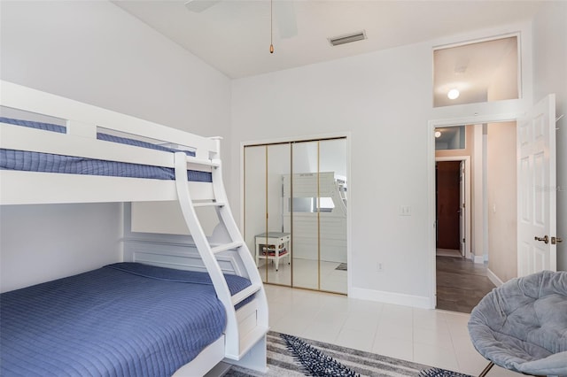 tiled bedroom with visible vents, a ceiling fan, and baseboards