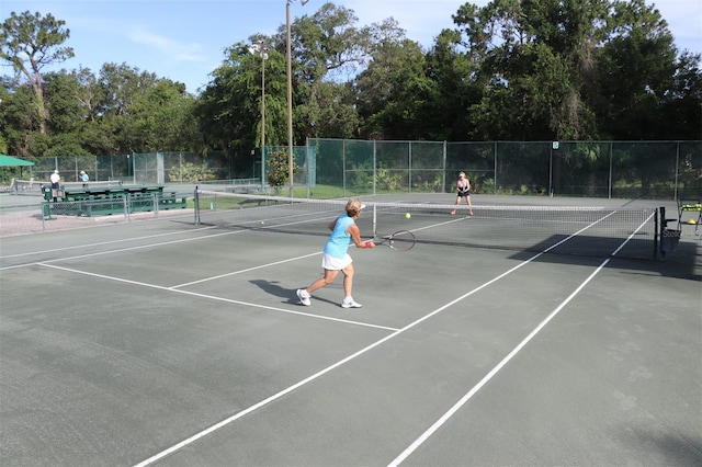 view of tennis court featuring fence