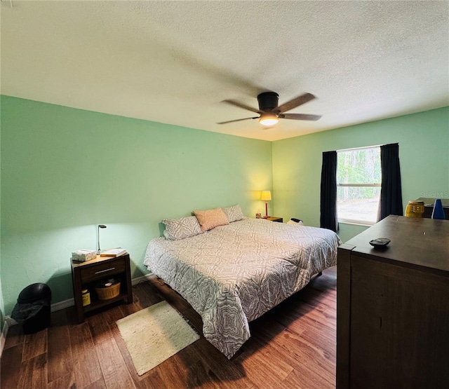 bedroom with a textured ceiling, wood finished floors, and a ceiling fan