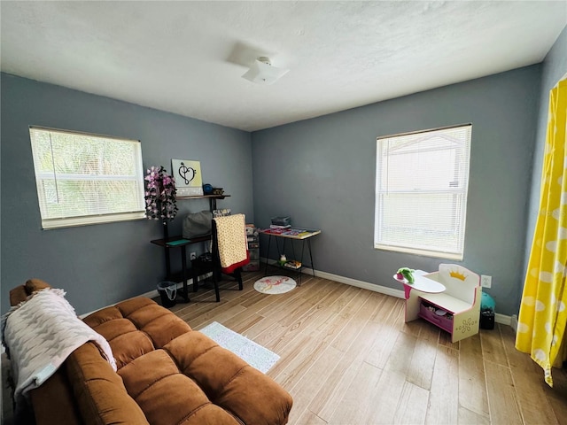 game room with baseboards and wood finished floors