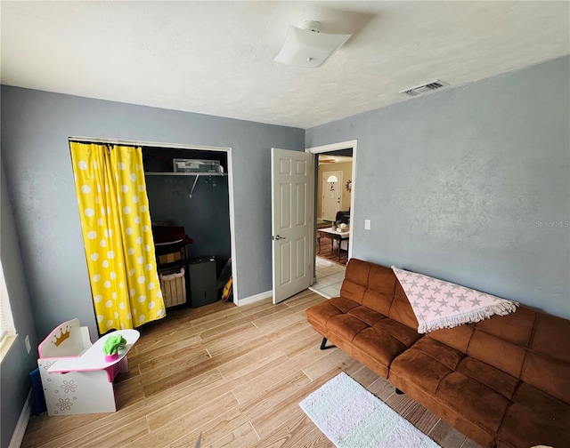 bedroom featuring visible vents, baseboards, light wood-style floors, and a closet