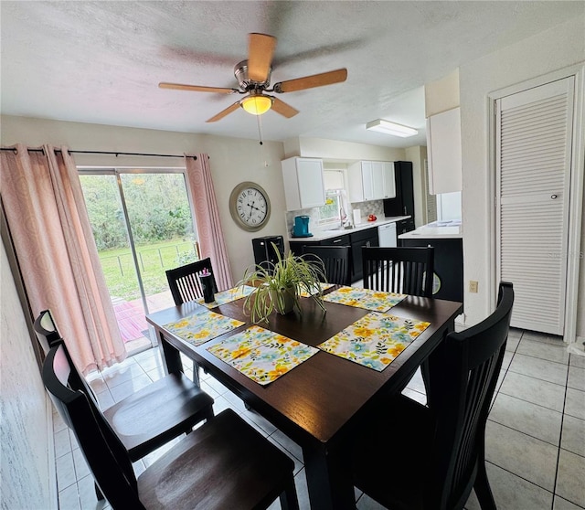 dining room featuring light tile patterned flooring, a textured ceiling, and ceiling fan