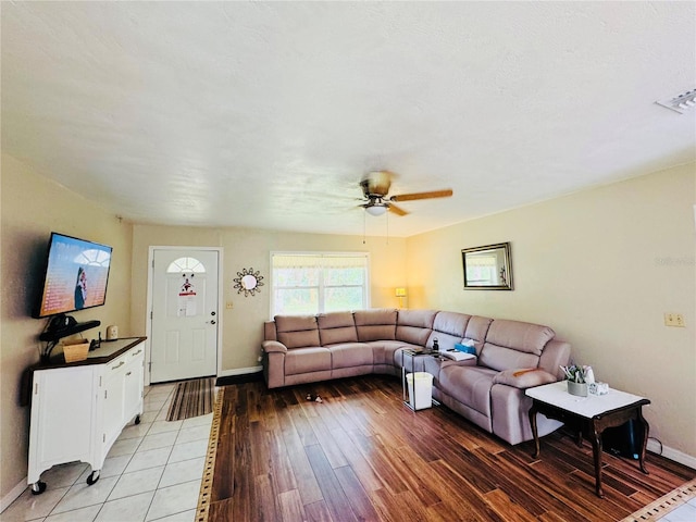 living room featuring light wood-type flooring, baseboards, visible vents, and a ceiling fan