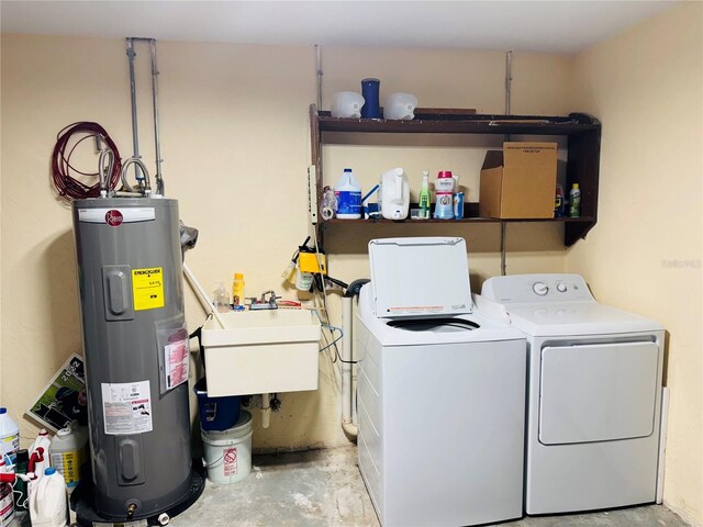 laundry area with water heater, laundry area, independent washer and dryer, and a sink