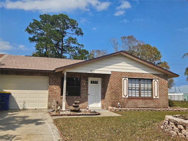 ranch-style house featuring roof with shingles, concrete driveway, a front yard, an attached garage, and brick siding