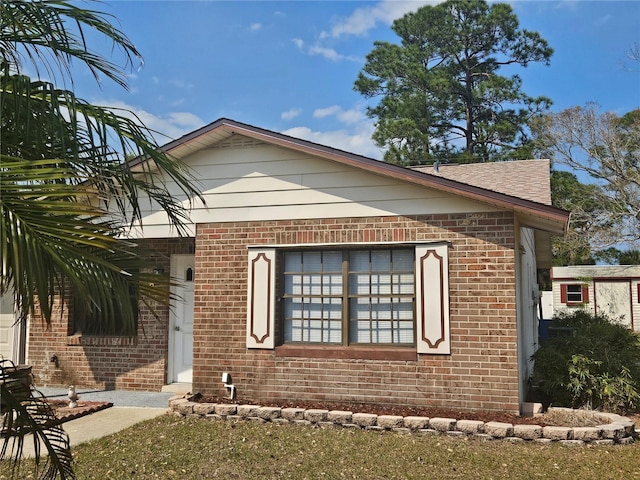 view of front of property featuring brick siding and a shingled roof