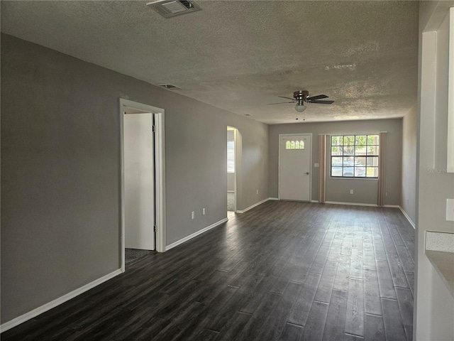 interior space with visible vents, dark wood-type flooring, baseboards, arched walkways, and a textured ceiling