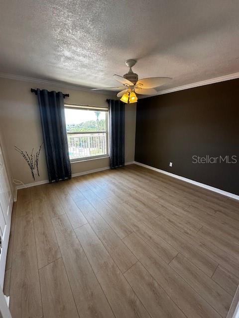 533 Marina Point Dr Unit 533, Daytona Beach, FL 32114 - empty room featuring baseboards, a textured ceiling, crown molding, ceiling fan, and wood finished floors