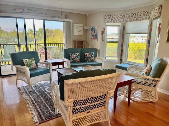 living room with ornamental molding, hardwood / wood-style flooring, baseboards, and a wealth of natural light