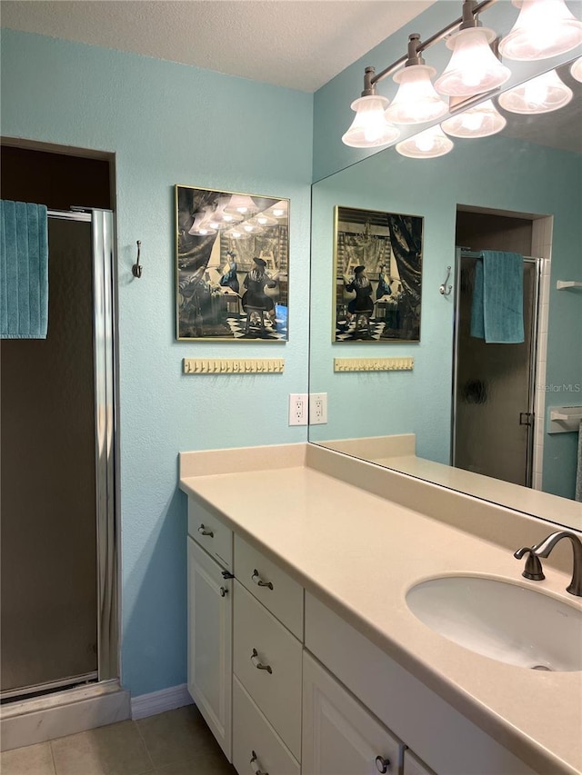 bathroom with vanity, a textured ceiling, tile patterned floors, and a shower stall