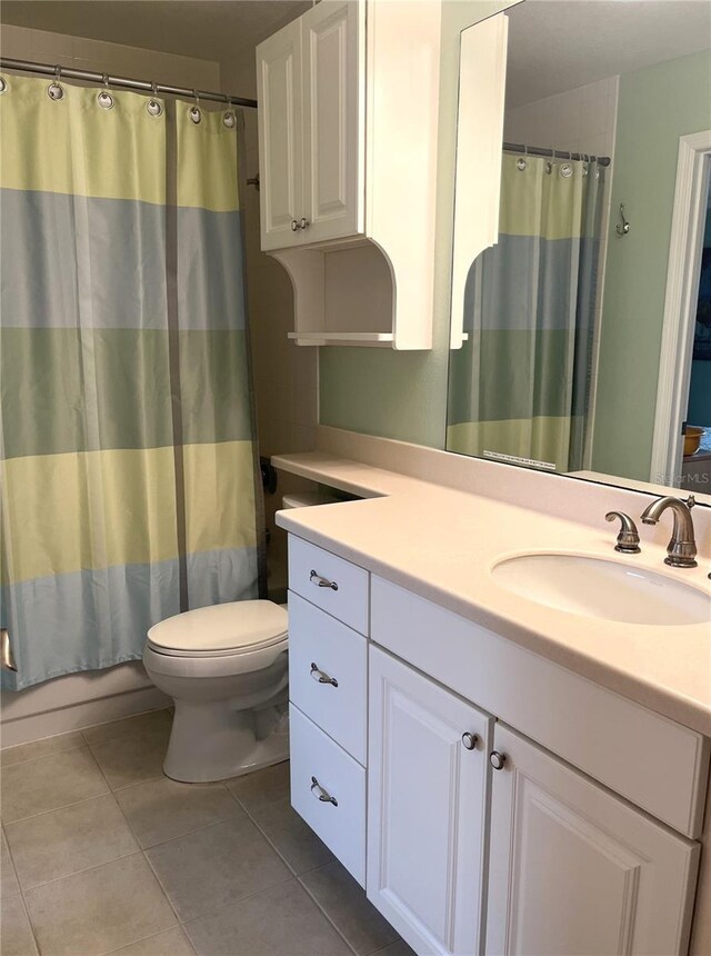 full bath featuring toilet, tile patterned floors, a shower with shower curtain, and vanity