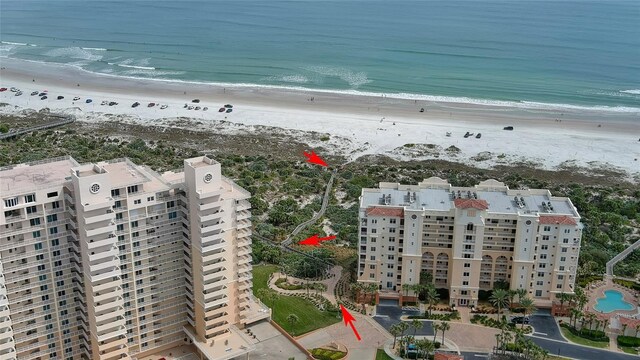 drone / aerial view featuring a beach view and a water view