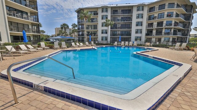 community pool featuring fence and a patio area